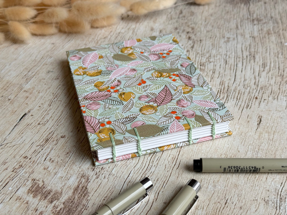Détail du papier de croquis et de la reliure cousue main du carnet Feuilles baies fruits sauge